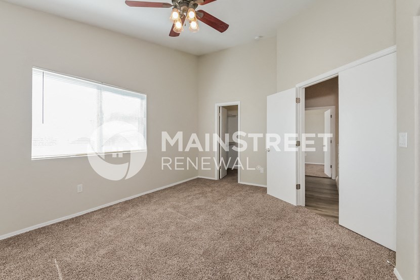 a bedroom with a carpeted floor and a ceiling fan