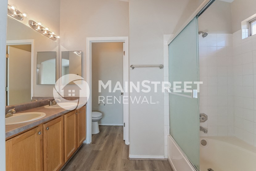 a bathroom with two sinks and a shower and a toilet