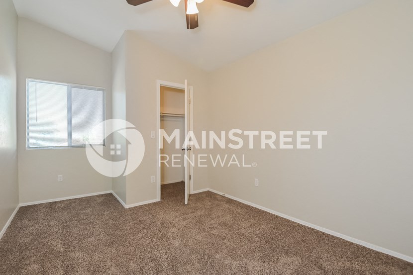 a bedroom with a closet and a carpeted floor