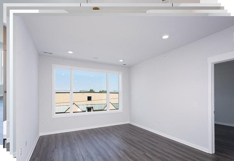 a living room with white walls and a large window