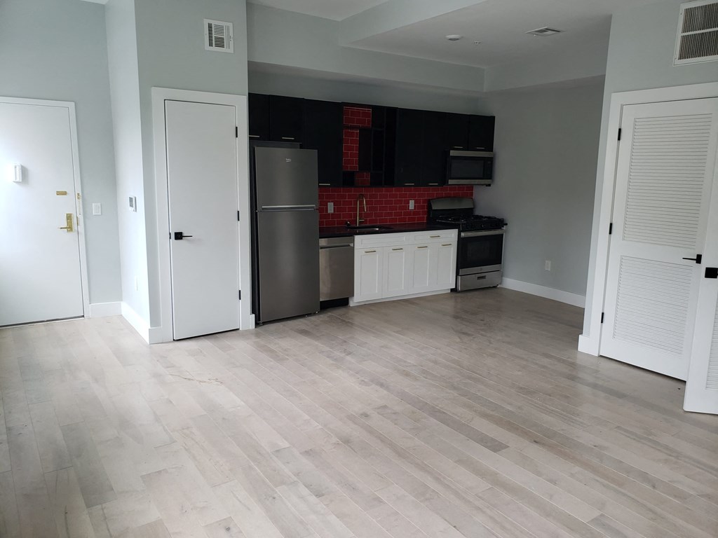 a kitchen with a refrigerator and a stove in a room