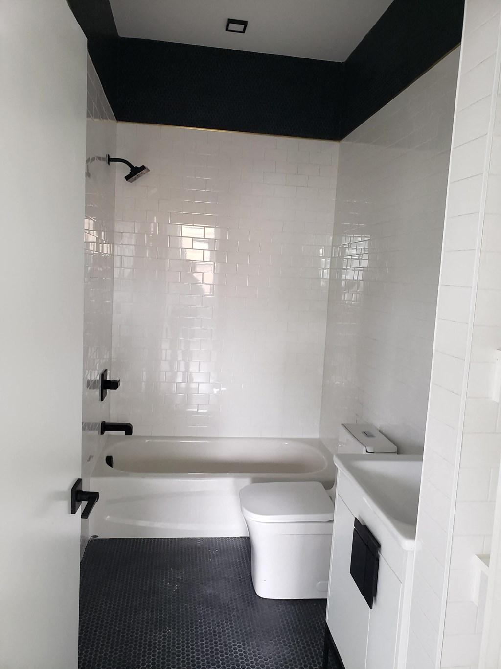 a bathroom with a toilet and a tub and a sink