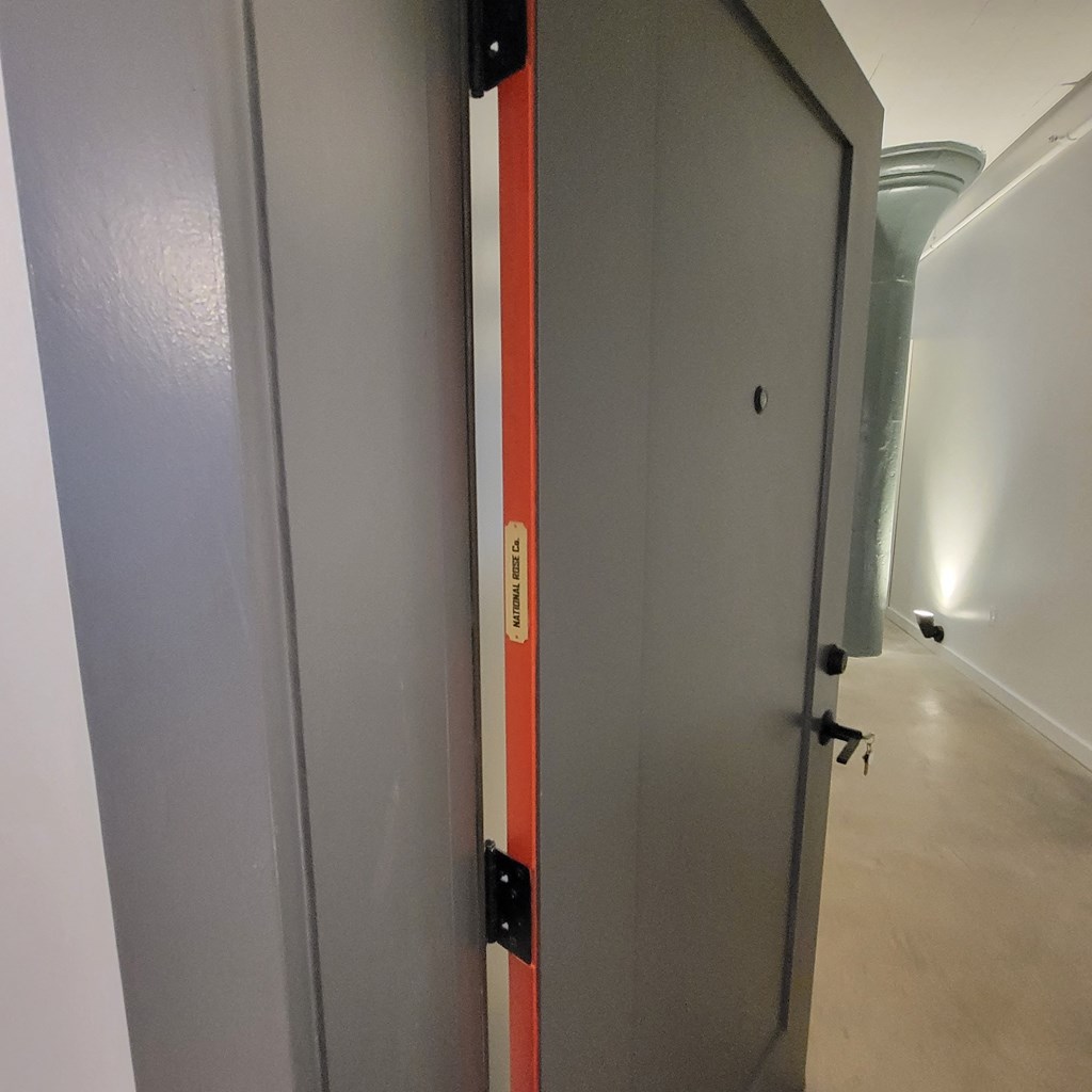 A grey door with a red stripe on the side is closed.