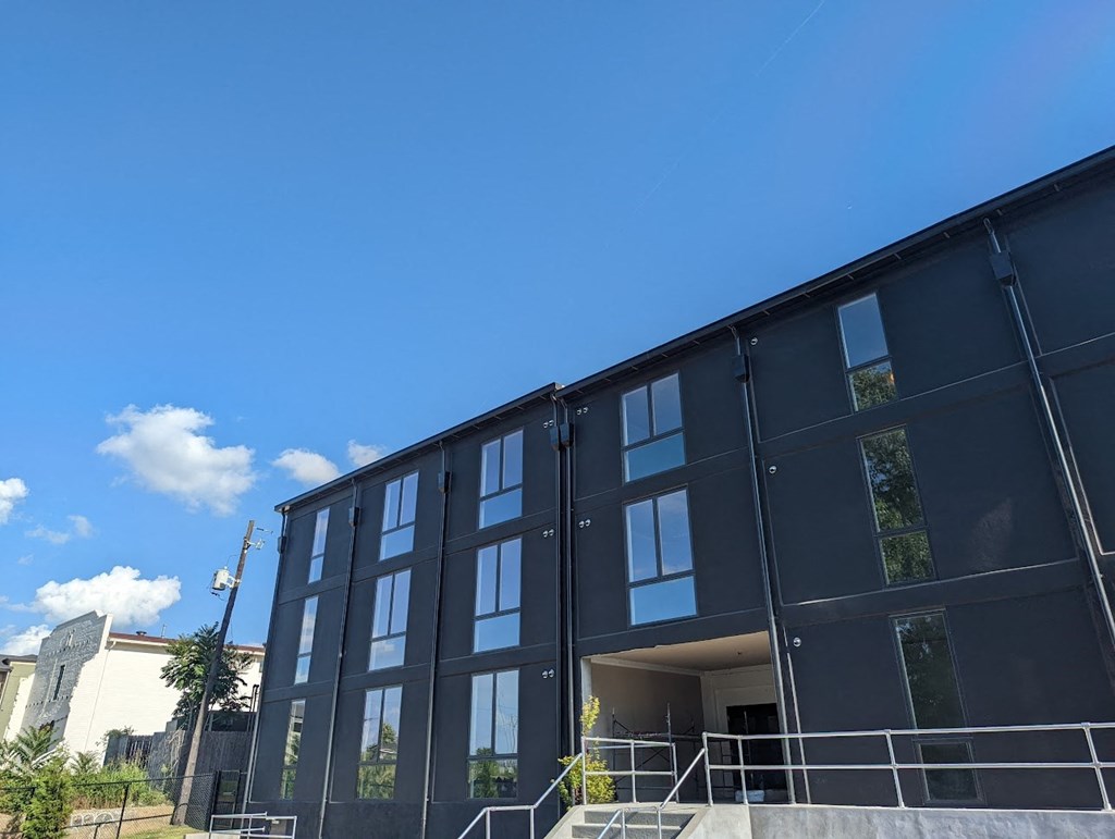 A modern building with a dark facade and large windows.
