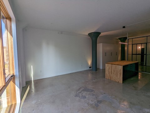 a living room with white walls and a wooden bar in the corner