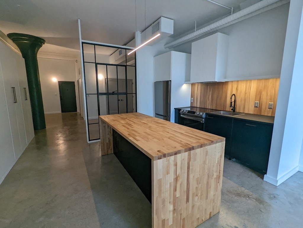 A kitchen with a wooden island in the middle of the room.