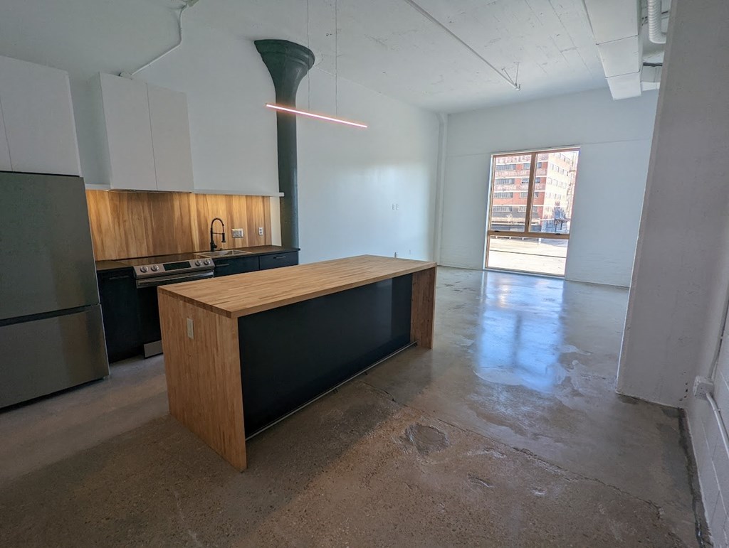 A kitchen with a wooden island in the middle of the room.