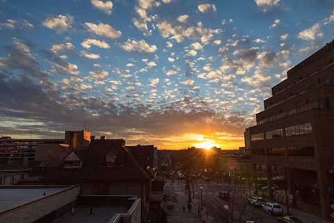 a sunset over a city with clouds in the sky