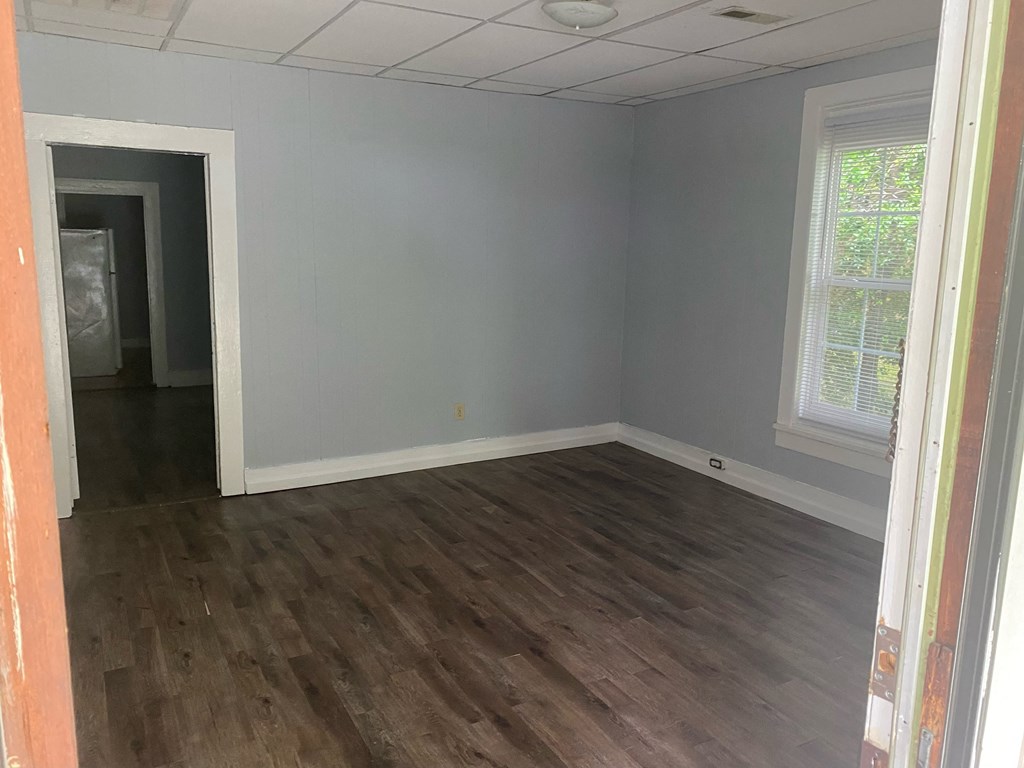 an empty living room with wood floors and grey walls