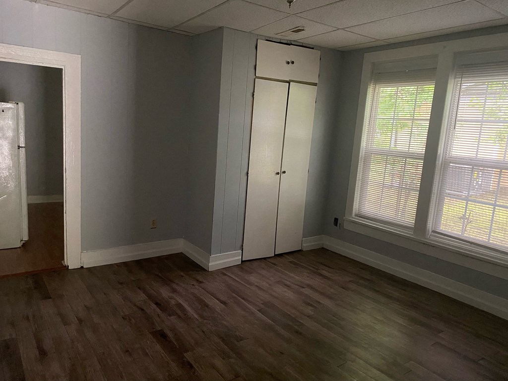 the living room with the closet and the hardwood floors
