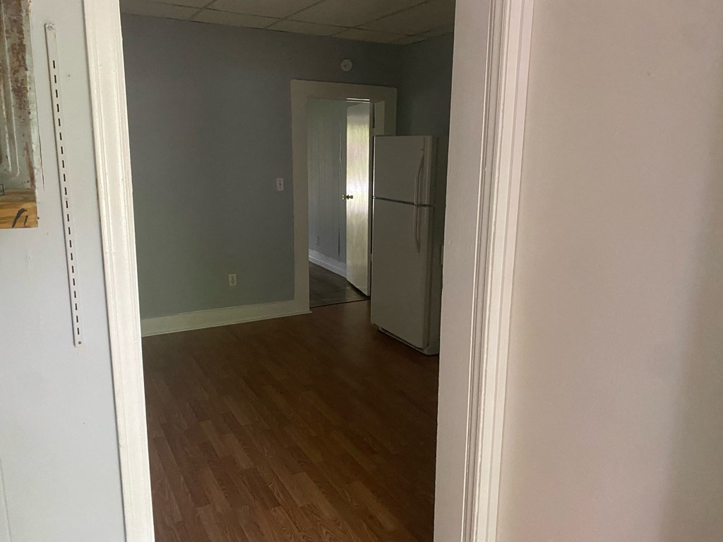 a room with a refrigerator and a hard wood floor