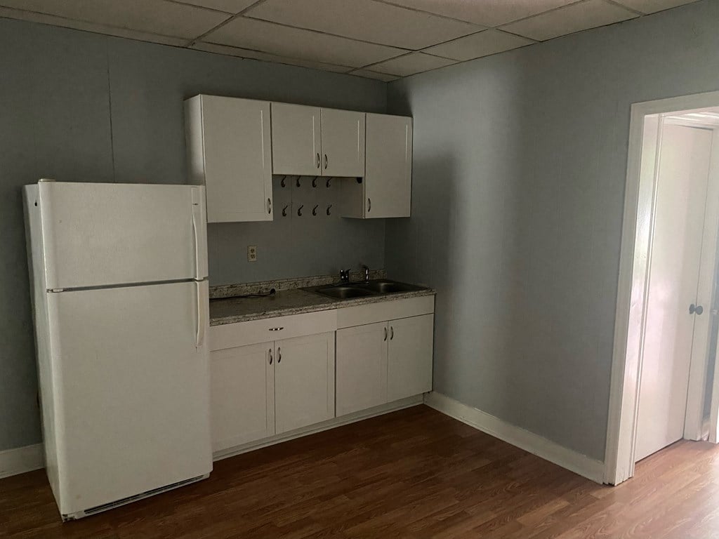 a kitchen with white cabinets and a refrigerator
