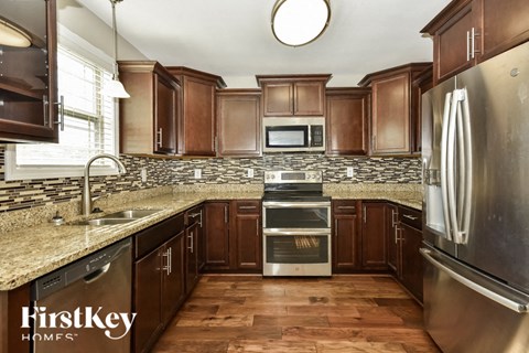 a kitchen with wooden cabinets and granite counter tops and stainless steel appliances