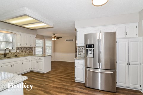 a kitchen with white cabinets and a stainless steel refrigerator
