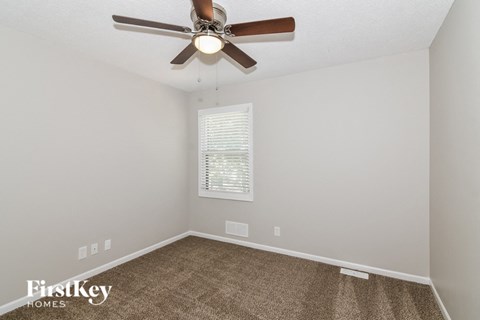 the living room has a ceiling fan and a carpet