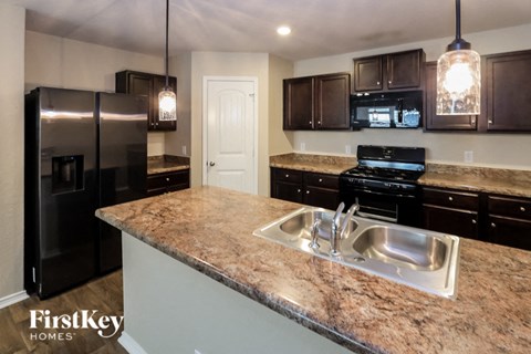 a kitchen with granite counter tops and black appliances