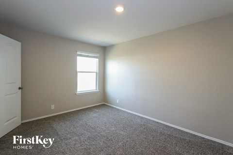 a bedroom with white walls and a window and carpet