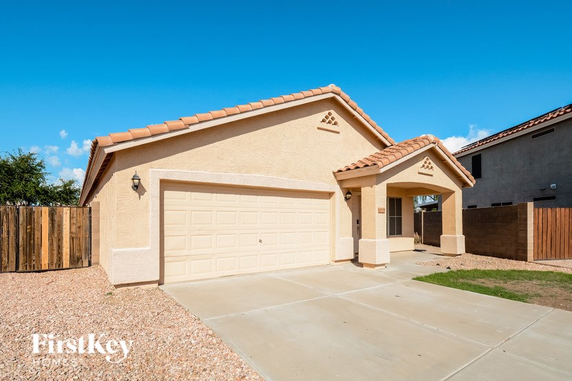A house with a garage and a driveway in front of it.