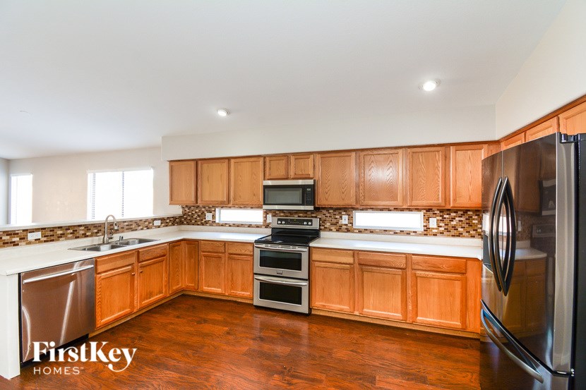 A kitchen with wooden cabinets and a refrigerator.