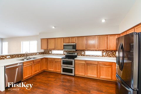 A kitchen with wooden cabinets and a refrigerator.