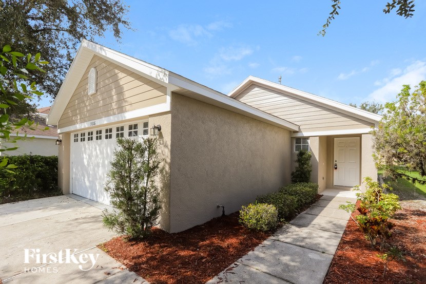 A modern house with a white door and a small garden in front.