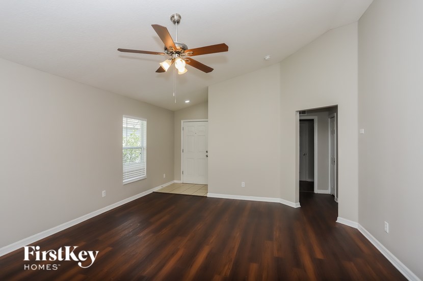 A room with a ceiling fan and wooden floors.