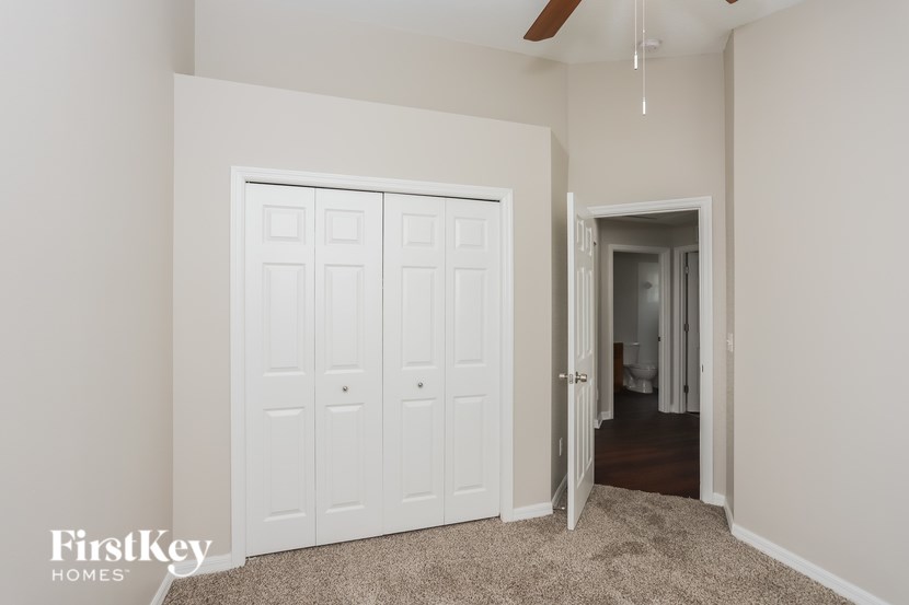 A white double door is in a room with a carpet.