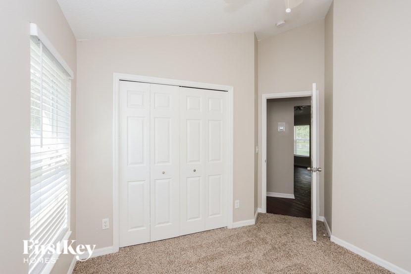 A white door with a window on the left and a carpeted floor.