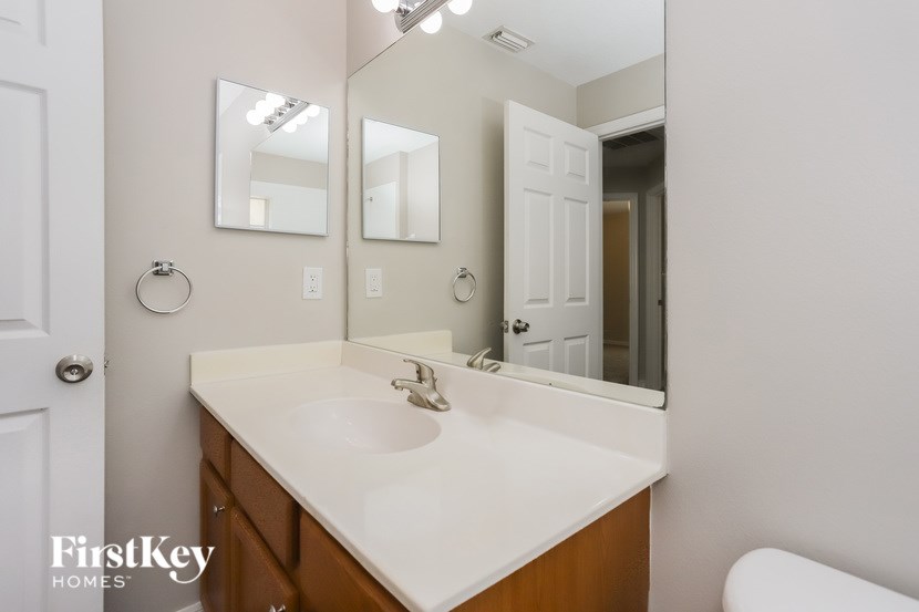 A bathroom with a white sink and mirrors.