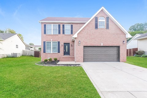 a brick house with a driveway and a garage door