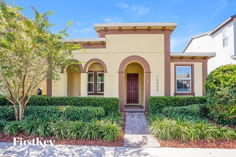a beige house with a door and a landscaped yard