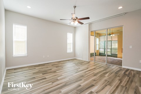 the living room with hardwood flooring and a ceiling fan