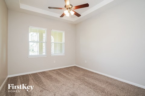 a bedroom with carpet and a ceiling fan