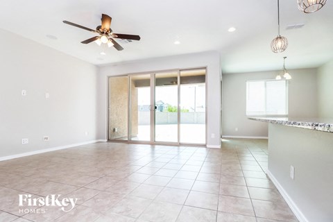 A spacious room with a ceiling fan and sliding glass doors.