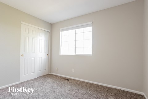 a bedroom with a white door and a window and carpet