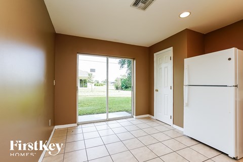 a kitchen with a door to a yard and a refrigerator