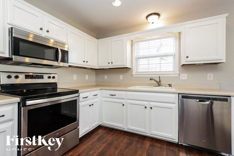 A kitchen with white cabinets and a stainless steel dishwasher.