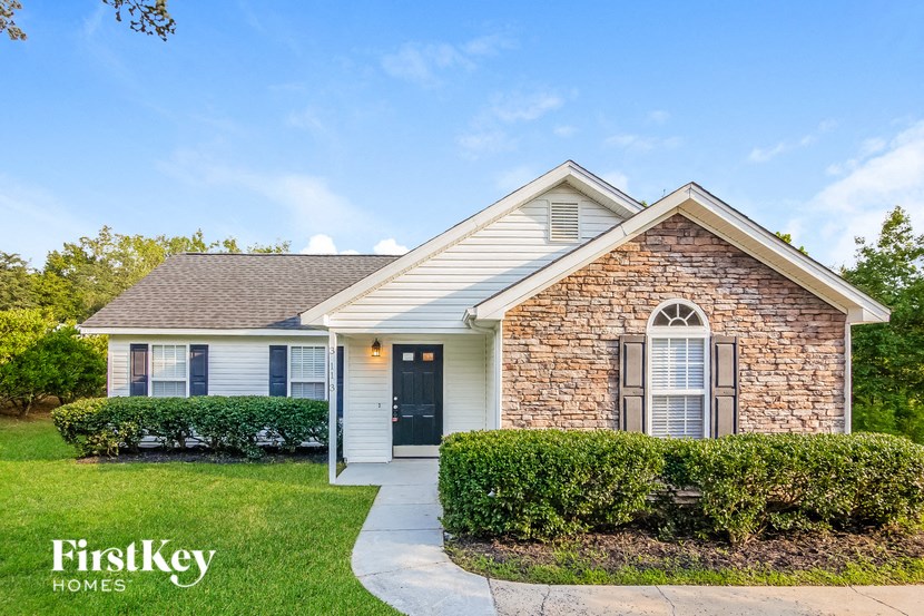 a small brick house with a sidewalk in front of it