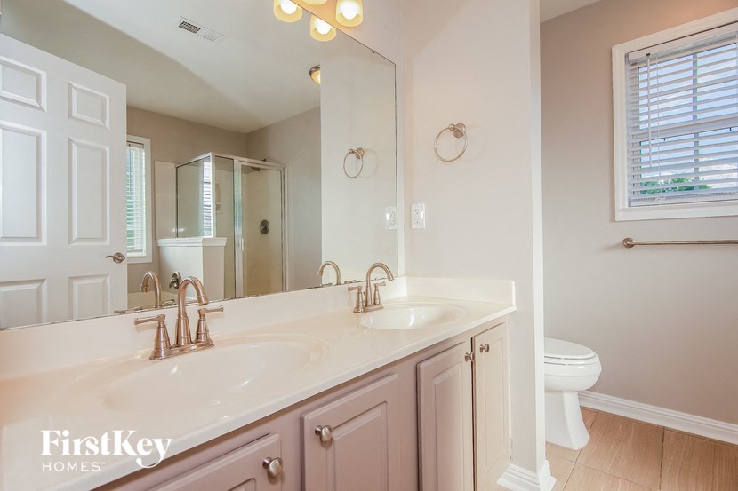 a bathroom with two sinks and a mirror and a toilet