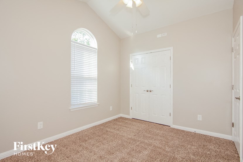 a bedroom with a carpeted floor and a white door
