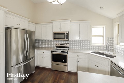 a kitchen with white cabinets and stainless steel appliances
