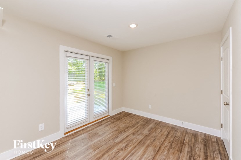 A room with wooden flooring and a sliding glass door.