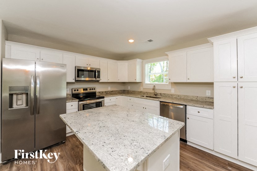 A kitchen with a granite countertop and stainless steel appliances.