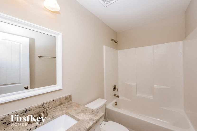 A bathroom with a tub, toilet and sink.