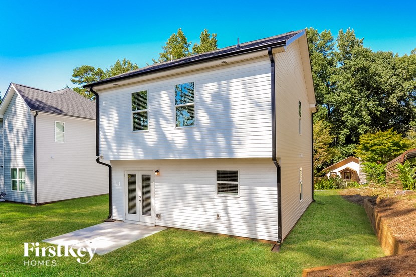 A white house with a brown roof and a small porch.