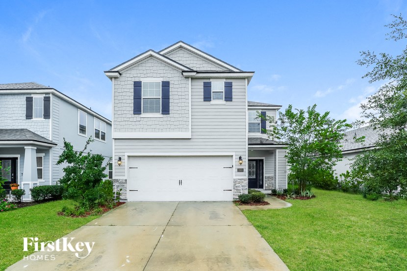 A white house with a garage is for sale by FirstKey Homes.
