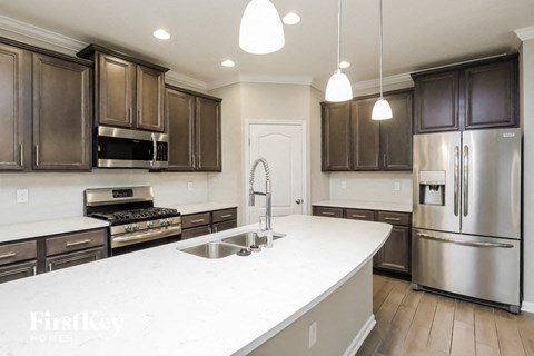 A kitchen with a white counter top and stainless steel appliances.