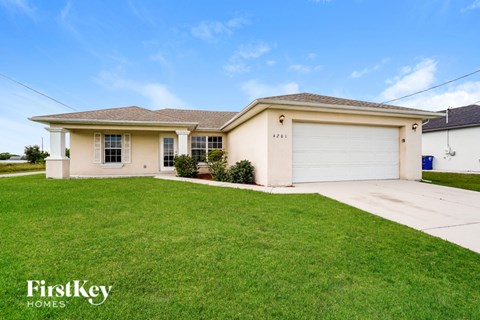 A house with a garage and a driveway in front of it.