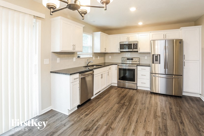 a kitchen with white cabinets and stainless steel appliances