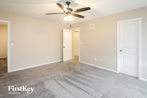 a living room with carpet and a ceiling fan